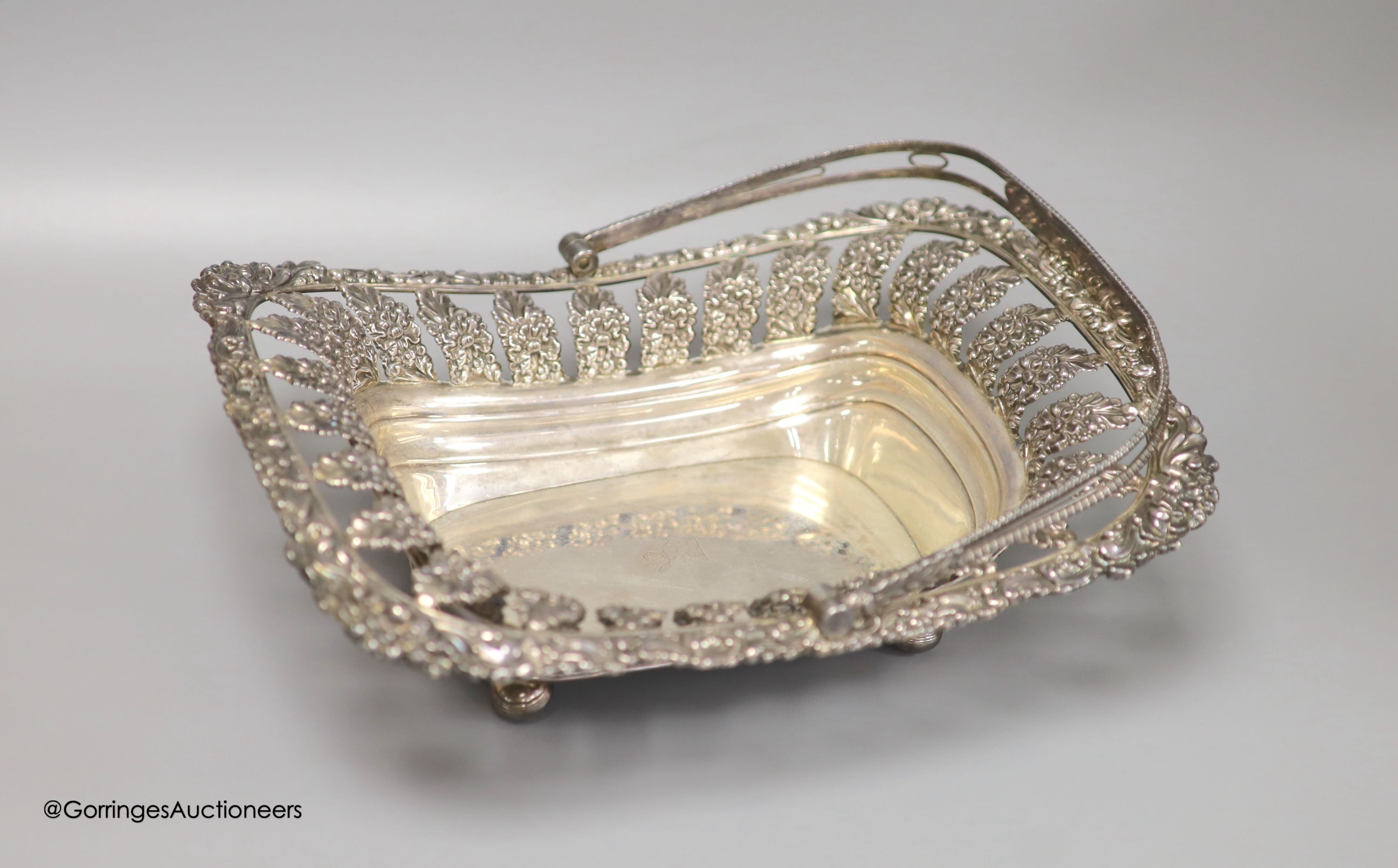A George III silver swing-handled cake basket with cast and embossed foliate decoration, 28.83oz